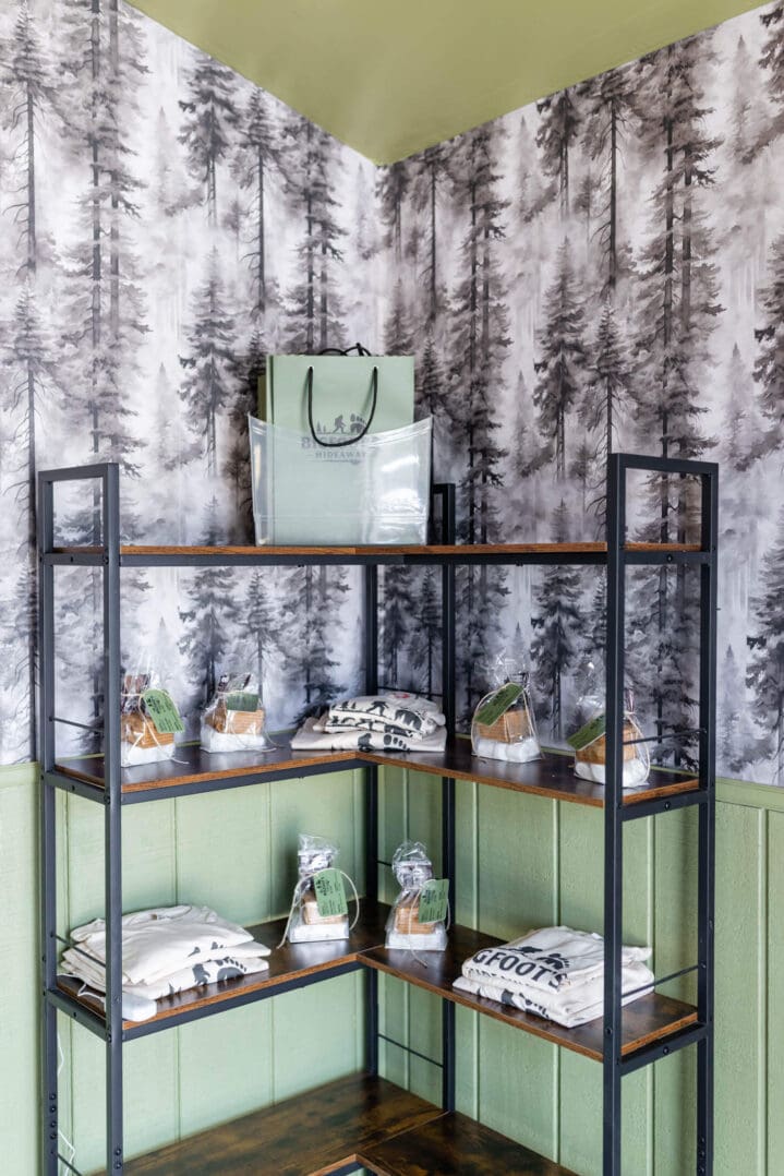 Corner shelving display with forest wallpaper