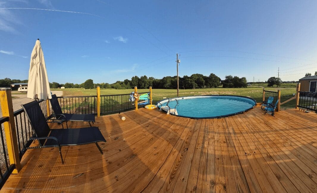Deck with pool and green landscape view.